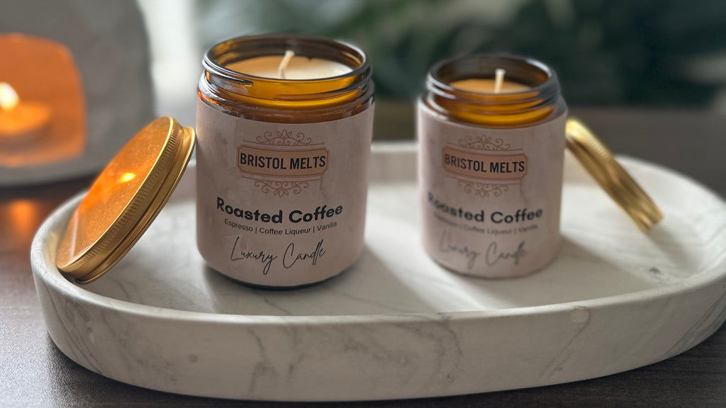 Two Bristol Melts candles labeled 'Roasted Coffee' on a marble tray with a blurred indoor background.